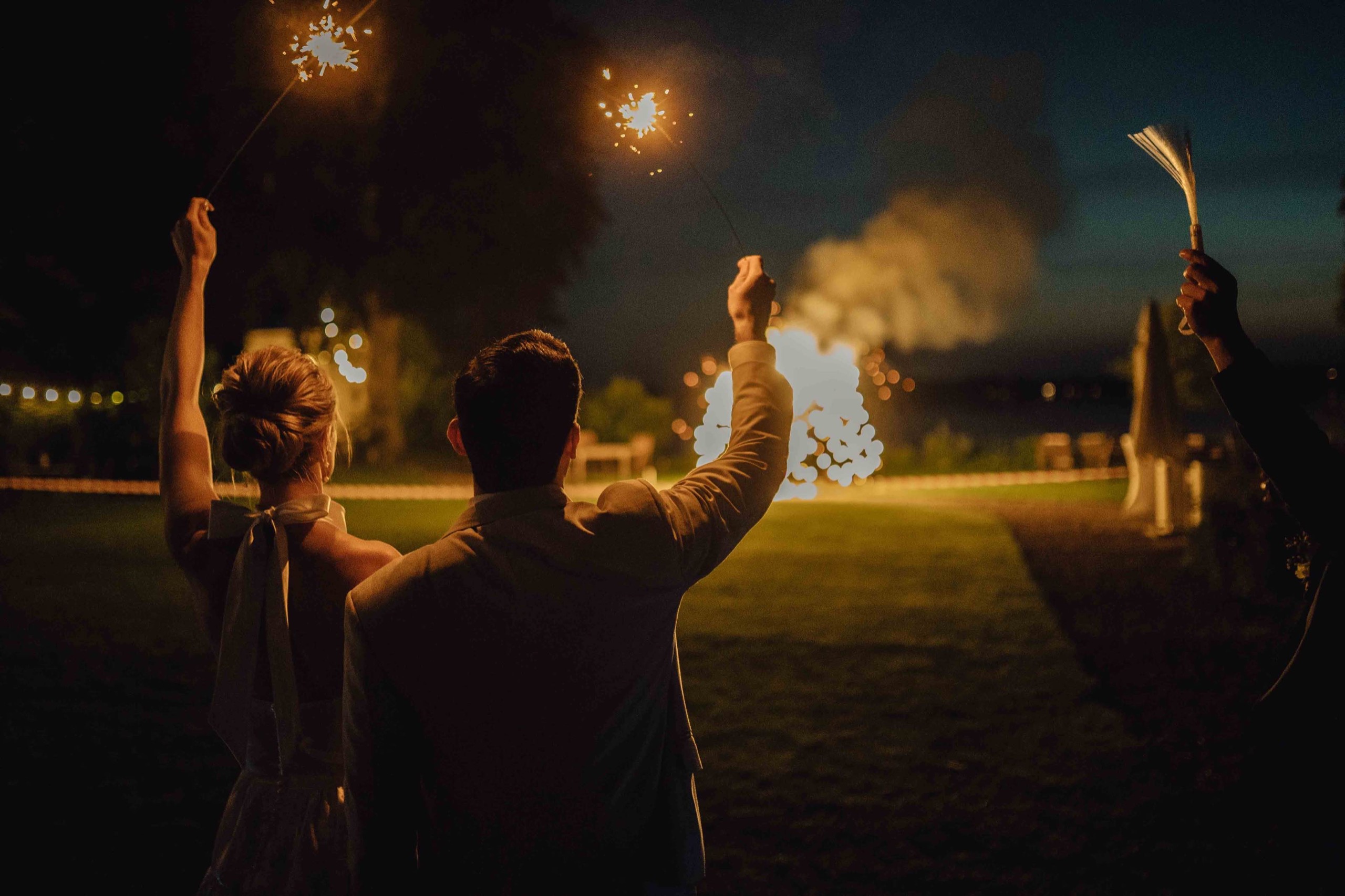 Hochzeitspaar und Gäste im Licht von Wunderkerzen